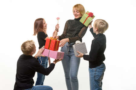 Children give a gift to mom, boys give a gift in boxes, flower girlの写真素材