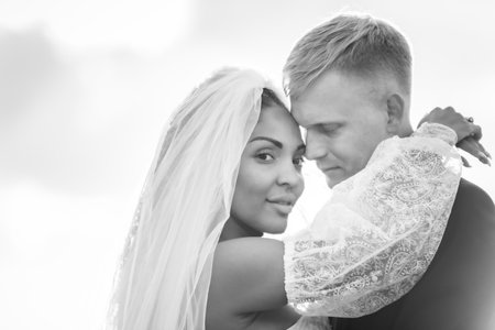 Happy newlyweds hugging in the rays of the setting sun, black and white versionの写真素材
