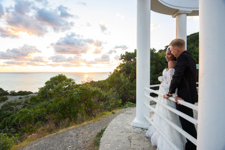 Newlyweds in a gazebo with columns on the seashoreの写真素材