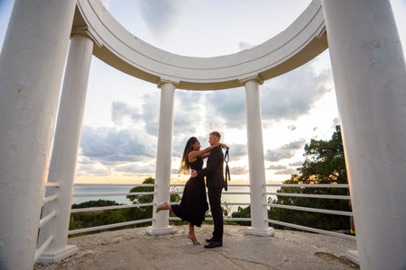 A young couple hugs in a gazebo against the backdrop of a beautiful landscapeの写真素材