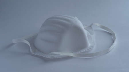 one medical face mask with safety glasses on white background, isolated, concept epidemic coronavirusの写真素材