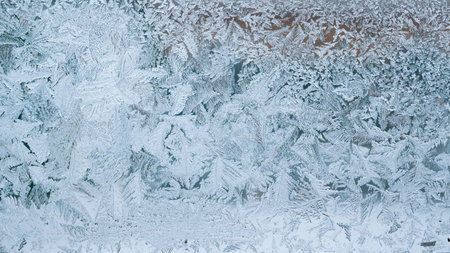Abstract view of frost on the window surface. Blue crystal frosty texture. Cold winter background.
