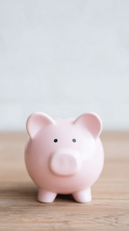 Piggy bank signifies saving routine, Financial discipline symbolized by pink coin container on table, Representation of personal budgeting and accumulating small financial achievements dailyの素材