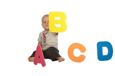 Little Baby Boy Sitting in Front of Colourful Lettersの写真素材