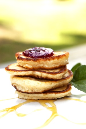Pancakes On A Plate Covered With Jam And Maple Syrup With Mint On The Sideの写真素材