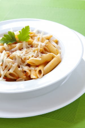Penne Pasta with Cheese and Parsley on a White Plateの写真素材
