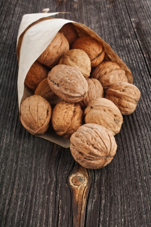 walnut nut in paper bag on texture surface of old wood backgroundの写真素材