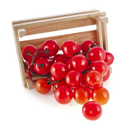 fresh ripe tomatoes in a wooden crate isolate on a white backgroundの写真素材