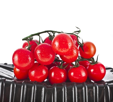 cherry tomatoes in the plastic container isolated on a white backgroundの写真素材
