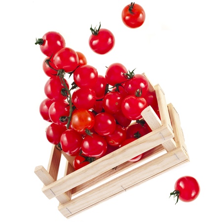 fresh ripe tomatoes in a wooden crate isolate on a white backgroundの写真素材