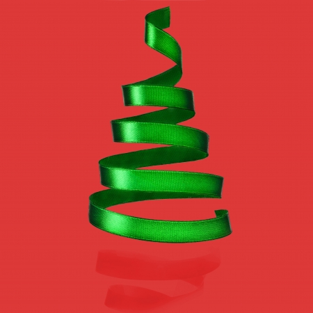 Christmas tree from green ribbon tape on red backgroundの写真素材