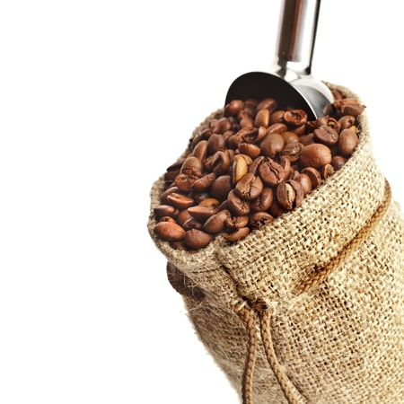 Burlap sack of coffee beans with metallic scoop on white backgroundの写真素材