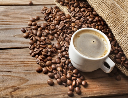 coffee cup and jute sack close-up on wooden table backgroundの写真素材