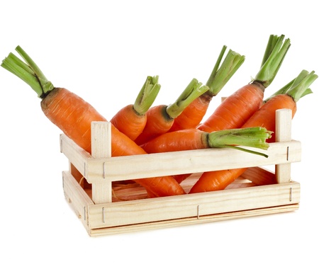 fresh carrots in a wooden crate box isolated on whiteの写真素材