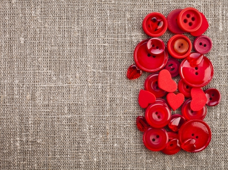 Border of red buttons and hearts on canvas burlap background textureの写真素材