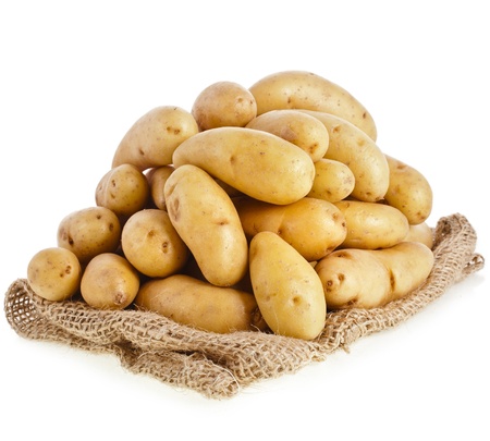 Raw potatoes heap with sack cloth isolated on a white backgroundの写真素材
