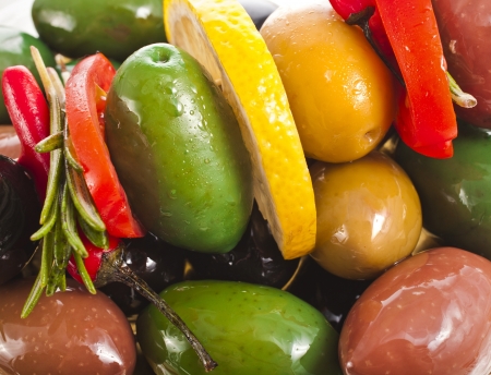 large multicolored olives heap with spice close up surface backgroundの写真素材