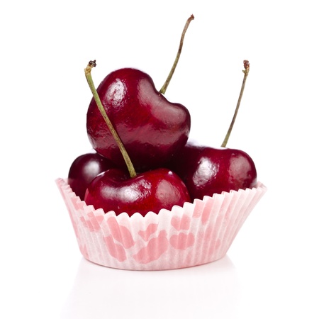 Red ripe cherries in a paper bowl isolated on white backgroundの写真素材