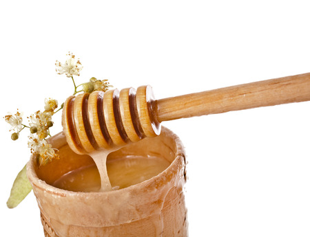 linden honey in barrel and honey stick isolated on white backgroundの写真素材