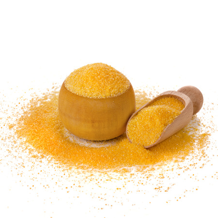 Uncoocked cornmeal maize flour heap and spoon scoop isolated on white の写真素材