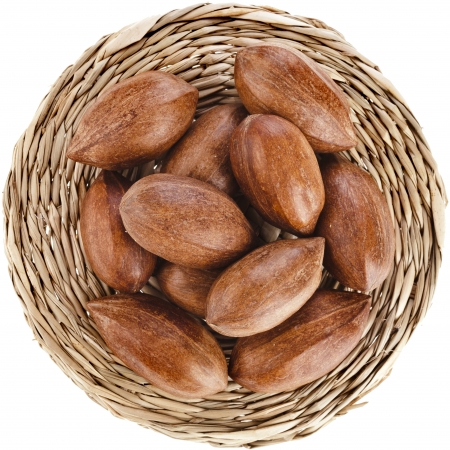 Pecan nuts in grass mat top view surface isolated on white backgroundの写真素材