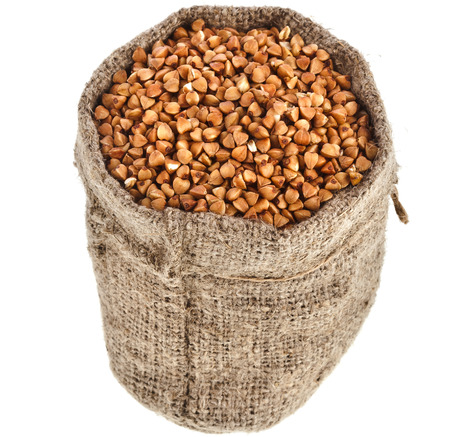 buckwheat grains in small burlap sack isolated on white backgroundの写真素材
