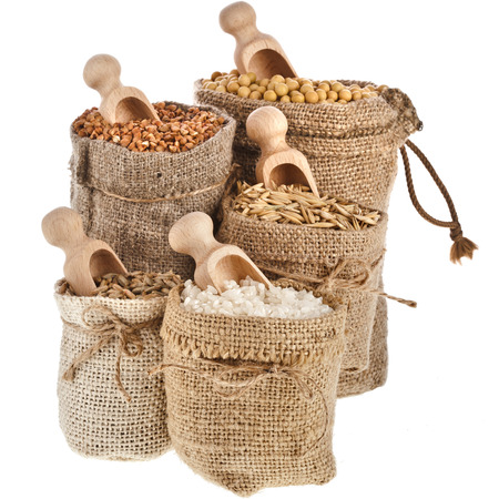 Corn kernel seed meal and grains in bags with wooden scoop isolated on a white backgroundの写真素材