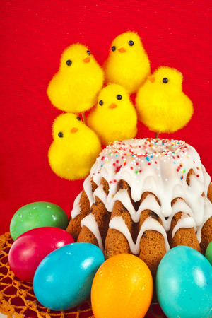 funny easter bread cake and colored egg with chickens on red backgroundの写真素材
