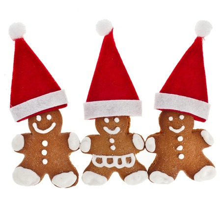 Three Gingerbread in santa red hat isolated on white backgroundの写真素材