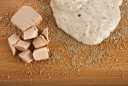 Rising Yeast Dough in bowl on wooden table surface backgroundの写真素材