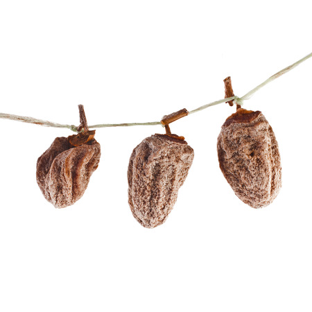 hanging bunch dried persimmon fruit isolated on white backgroundの写真素材
