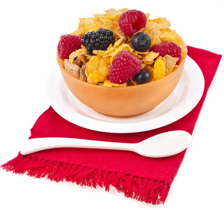 corn flakes with fresh berries in bowl plate isolated on white backgroundの写真素材