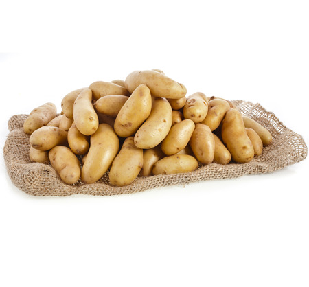Raw potatoes heap with sack cloth isolated on a white backgroundの写真素材