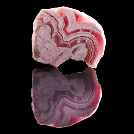 Rhodochrosite stone with reflection on black surface backgroundの写真素材