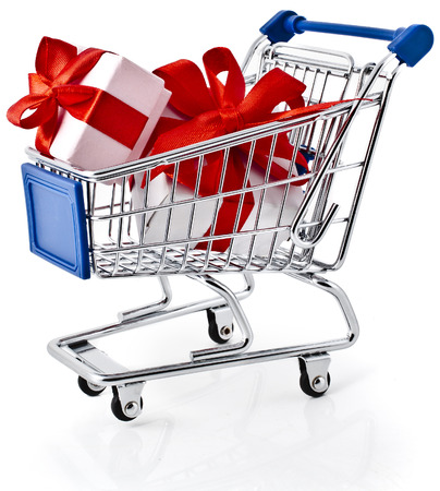 Shopping basket cart full of gift boxes tied with ribbons - isolated on white backgroundの写真素材