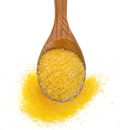 cornmeal maize flour heap in wooden spoon isolated on white backgroundの写真素材