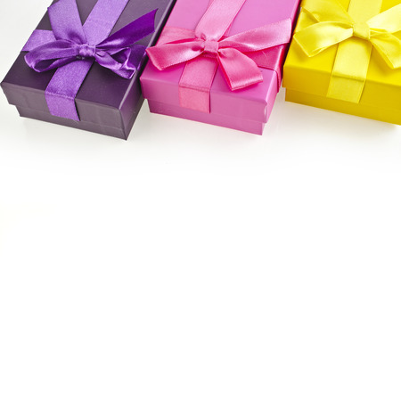 colorful gift boxes wrapped ribbon bows surface close up isolated on white backgroundの写真素材