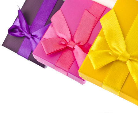 colorful gift boxes wrapped ribbon bows surface close up isolated on white backgroundの写真素材