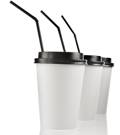 Disposable cup for hot drinks with black top and straw isolated on white backgroundの写真素材