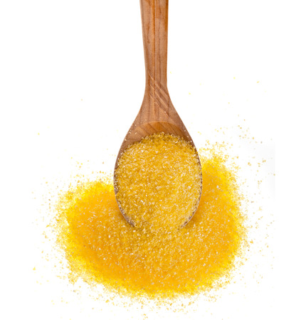cornmeal maize flour heap in wooden spoon isolated on white backgroundの写真素材
