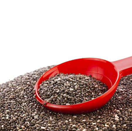 chia seeds in red scoop close up isolated on whiteの写真素材