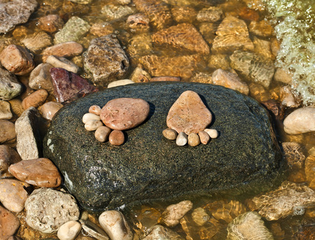 The footprint made up of stones on a stone island in the sea beach backdropの写真素材