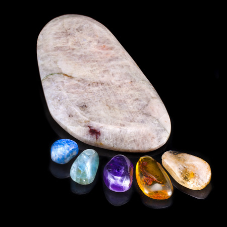trace foot made of natural colorful raw gem-stones on black surface backgroundの写真素材