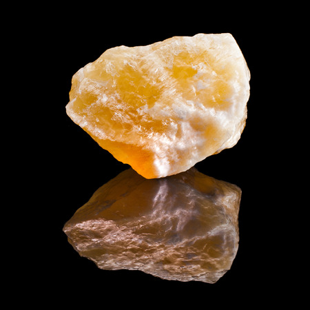 Calcite crystal with reflection on black surface backgroundの写真素材