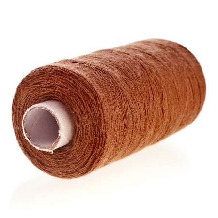 Bobbin of brown cotton thread close up isolated on white backgroundの写真素材