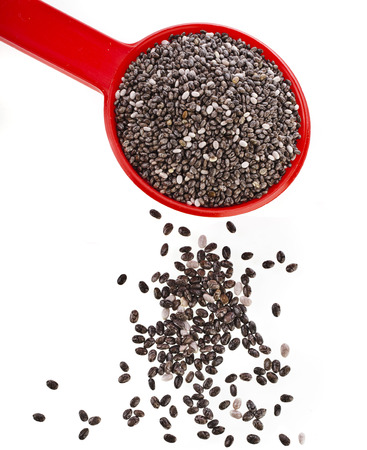 chia seeds in red scoop close up isolated on whiteの写真素材