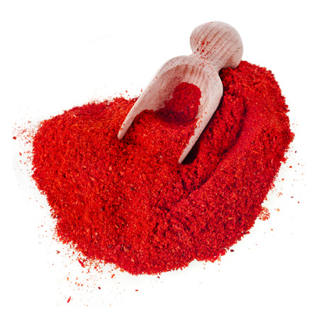 powder paprika heap with wooden spoon scoop close up isolated on white backgroundの写真素材