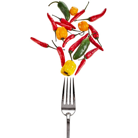 fork with falling variety vegetables pepper paprika isolated on a white backgroundの写真素材