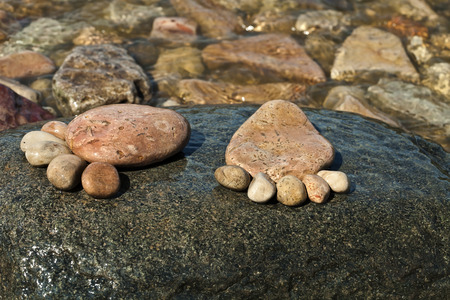 The footprint made up of stones on a stone island in the sea beach backdropの写真素材