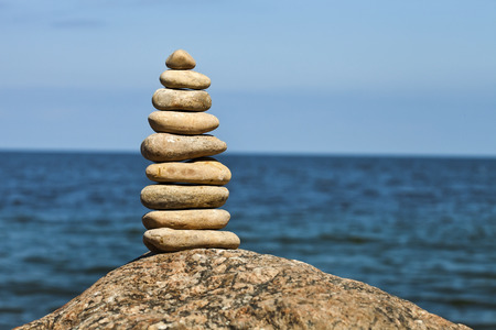 The pyramid of stone pebbles on background of the sea surface with copy spaceの写真素材